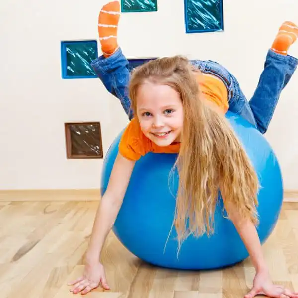 Child using a therapy exercise ball during pediatric therapy