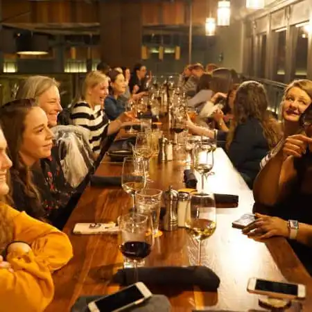 Group of people enjoying a social gathering and conversation at a restaurant table