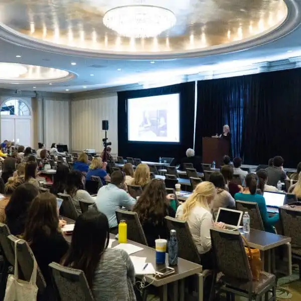 Audience attending a presentation or educational conference in a large meeting room